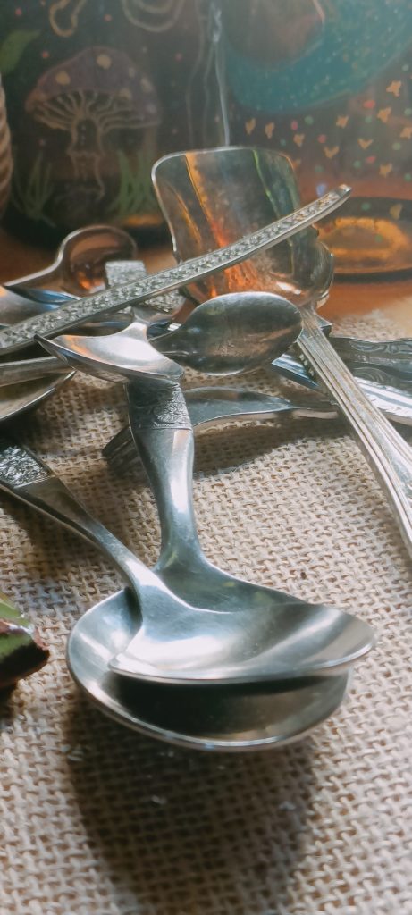 a collection of vintage silver flatware on a hessian cloth